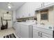 Laundry room with white cabinets, washer, dryer, and utility sink at 3075 Bay Oaks Cir, Englewood, FL 34223