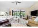 Spacious living area featuring a large TV and pool view at 3075 Bay Oaks Cir, Englewood, FL 34223