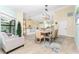 Bright dining room featuring a large table, chandelier, and view into the living room at 3075 Bay Oaks Cir, Englewood, FL 34223