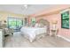 Main bedroom with king-size bed, light walls, and access to a private balcony at 3075 Bay Oaks Cir, Englewood, FL 34223