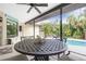 Outdoor patio with pool view, dining table, and ceiling fan at 3075 Bay Oaks Cir, Englewood, FL 34223