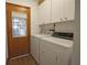 Laundry room with washer, dryer, and cabinets at 412 Cypress Forest Dr, Englewood, FL 34223