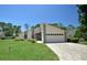 Single-story home with a paved driveway and well-manicured lawn at 412 Cypress Forest Dr, Englewood, FL 34223