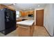 Bright kitchen with an island, wood cabinets, and black appliances at 412 Cypress Forest Dr, Englewood, FL 34223