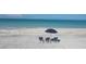 Relaxing beach setup with lounge chairs and umbrella at 5000 Gasparilla Rd # Dc102, Boca Grande, FL 33921