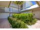 Building entry with lush green landscaping at 5000 Gasparilla Rd # Dc102, Boca Grande, FL 33921