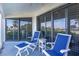 Screened porch with two chairs, footrests, and ocean view at 5000 Gasparilla Rd # Dc102, Boca Grande, FL 33921
