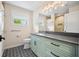 Modern bathroom with light green vanity, patterned tile floor, and walk-in shower at 5208 Churchill Rd, Port Charlotte, FL 33981