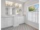 Luxurious bathroom with double vanity and patterned floor tiles at 5208 Churchill Rd, Port Charlotte, FL 33981