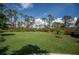 Large backyard with lush landscaping and mature trees at 5208 Churchill Rd, Port Charlotte, FL 33981