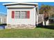 Mobile home with red shutters and brick skirting at 5560 Holiday Park Blvd, North Port, FL 34287