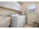 Laundry room with washer, dryer, cabinets, and utility sink at 665 Rotonda Cir, Rotonda West, FL 33947