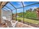 Enjoy the view from this relaxing screened patio with white adirondack chairs at 10852 Lerwick Cir, Englewood, FL 34223