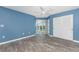 Spacious bedroom with blue walls, wood-look tile flooring, ceiling fan, and built-in shelves at 1401 S Mccall Rd # A 305, Englewood, FL 34223