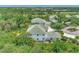 Aerial view of a two-story house with green roof and lush landscaping at 14080 Willow Glen Ct # 233, Port Charlotte, FL 33953