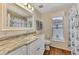 Bathroom with granite countertop, white cabinets and a shower/tub combo at 14080 Willow Glen Ct # 233, Port Charlotte, FL 33953