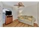 Cozy bedroom with a sofa, flat-screen TV and wood-look flooring at 14080 Willow Glen Ct # 233, Port Charlotte, FL 33953