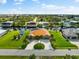 Aerial view of canal-front home with circular driveway, lush landscaping, and dock at 15204 Brainbridge Cir, Port Charlotte, FL 33981