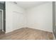 A white bedroom with light wood-look flooring and a large closet behind bi-fold doors at 19524 Fishhawk Trl, Venice, FL 34293