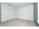Empty bedroom showing carpet flooring, white walls, closet, and natural light at 19524 Fishhawk Trl, Venice, FL 34293