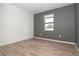 A bright, empty bedroom with a window and neutral-colored walls and wood-look flooring at 19524 Fishhawk Trl, Venice, FL 34293