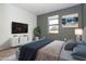 Modern main bedroom with a gray accent wall, stylish furniture, and a large window at 19524 Fishhawk Trl, Venice, FL 34293