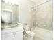 A well-lit bathroom features a granite vanity, tub with tile surround, and modern fixtures at 19536 Fishhawk Trl, Venice, FL 34293