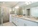 Bright bathroom featuring double vanity with granite countertops, a tiled shower and glass doors at 19536 Fishhawk Trl, Venice, FL 34293