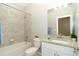 Bright bathroom with a shower-tub, granite countertop vanity, and white cabinets at 19536 Fishhawk Trl, Venice, FL 34293