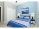 Modern bedroom with blue walls, closet, and gray bed with blue accents and a matching abstract painting at 19536 Fishhawk Trl, Venice, FL 34293