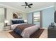 Cozy bedroom features plush bedding, stylish decor, and a ceiling fan for added comfort at 19536 Fishhawk Trl, Venice, FL 34293