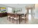 Dining room with large table set for eight, neutral walls, crown molding and large window at 19536 Fishhawk Trl, Venice, FL 34293