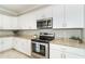Well-equipped kitchen with stainless steel appliances, white cabinets, and granite countertops at 19536 Fishhawk Trl, Venice, FL 34293