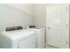 Laundry room with new washer, dryer, shelving and a white door at 19536 Fishhawk Trl, Venice, FL 34293