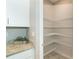 Walk-in pantry features white wire shelving and granite countertop at 19536 Fishhawk Trl, Venice, FL 34293