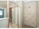 Modern walk-in shower with glass enclosure and a view of the bathroom with double vanity and separate toilet room at 19536 Fishhawk Trl, Venice, FL 34293