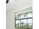 Large window with white blinds overlooking lush greenery and palm trees at 19536 Fishhawk Trl, Venice, FL 34293