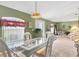 Dining area with glass table, white chairs and stained glass light at 3 Pinehurst Ct, Rotonda West, FL 33947