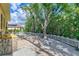 Landscaped backyard with gravel pathway, white fence, and mature trees at 3060 Rivershore Ln, Port Charlotte, FL 33953
