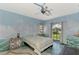 Bedroom with ocean-themed mural, a ceiling fan, and a view of the backyard at 3060 Rivershore Ln, Port Charlotte, FL 33953