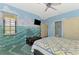 Bright bedroom with ocean-themed murals, a ceiling fan and large windows at 3060 Rivershore Ln, Port Charlotte, FL 33953