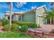 Green house exterior with lush landscaping and brick walkway at 3155 Osprey Ln, Port Charlotte, FL 33953