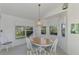 Dining room features wood table, white chairs, and a view to the backyard at 3270 Bay Ridge Way, Port Charlotte, FL 33953