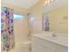 Charming bathroom with floral shower curtain and white vanity at 3270 Bay Ridge Way, Port Charlotte, FL 33953