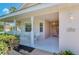 Covered porch with white wicker furniture and landscaping at 3270 Bay Ridge Way, Port Charlotte, FL 33953