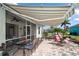 Outdoor patio with striped awning, seating, and a table at 644 Barnacle Ct, Englewood, FL 34223