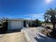 Front view of a single-story home with a white garage door and palm trees at 9 Annapolis Ln, Rotonda West, FL 33947