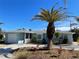 Newly renovated light blue home with palm trees and a gravel driveway at 9 Annapolis Ln, Rotonda West, FL 33947