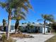 Light blue single story home with palm trees and a gravel driveway at 9 Annapolis Ln, Rotonda West, FL 33947