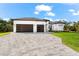 Modern two-car garage home with light gray pavers driveway and landscaped lawn at 10107 Boylston St, Port Charlotte, FL 33981